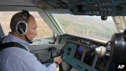Russia's Prime Minister Vladimir Putin sits in the cabin of a Russian firefighting aircraft Be-200 during the firefighting effort in Rayzan region some 250 km outside Moscow, 10 Aug 2010