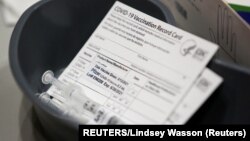 Potvrde o vakcinaciji na jednom od punktova za imunizaciju (Foto: REUTERS/Lindsey Wasson)