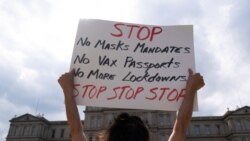 Seorang pengunjuk rasa memegang poster yang berisi pesan penolakan terhadap mandat vaksin yang akan diberlakukan di AS dalam sebuah protes di Gedung Pemerintahan Michigan, AS. (Foto: Thomson Reuters)