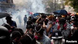 Para pengunjuk rasa berusaha menghindari gas air mata saat mencoba meninggalkan kampus Universitas Politeknik Hong Kong (PolyU) selama bentrokan dengan polisi di Hong Kong, 18 November 2019.