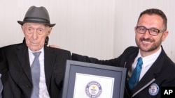 Dalam foto yang dirilis Guinness World Records, Marco Frigatti, kepala rekor untuk Guinness World Records, menganugerahkan Israel Kristal sertifikat sebagai orang tertua di dunia, Haifa, Israel, 11 Maret 2016. (Foto:dok)