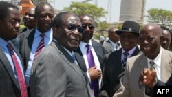 FILE - Zimbabwe's President Robert Mugabe (C-L) greets local chiefs at Zimplats mine, outside Harare.