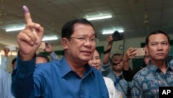 FILE - Cambodian Prime Minister Hun Sen of the Cambodian People's Party shows off his inked finger after voting in local elections at Takhmau polling station in Kandal province, southeast of Phnom Penh, Cambodia, Sunday, June 4, 2017. (AP Photo/Heng Sinith)