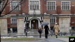 FILE - People walk near the campus center at Princeton University in Princeton, N.J., Dec. 9, 2013. 