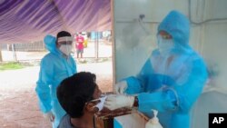 បុគ្គលិក​សុខាភិបាល​ម្នាក់​យក​សំណាក​សំបោរ​ដើម្បី​ធ្វើ​តេស្ត​សម្រាប់​ជំងឺ​កូវីដ១៩ នៅ​ក្នុង​ក្រុង Hyderabad ប្រទេស​ឥណ្ឌា កាលពី​ថ្ងៃទី១៣ ខែកញ្ញា ឆ្នាំ២០២០។