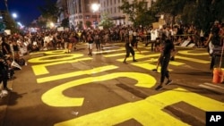 Demonstrators paint the words 'defund the police' as they protest Saturday, June 6, 2020, near the White House in Washington, over the death of George Floyd, a black man who was in police custody in Minneapolis. Floyd died after being restrained by…