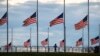A jogger passes flags flying at half-staff at the Washington Monument on the National Mall following the death of former U.S. President Jimmy Carter, in Washington, Dec. 30, 2024. 