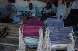 FILE - Tailors make face masks at the Tayamba Tailoring shop, which has embarked in the business of producing face masks intended to protect against the COVID-19 coronavirus, in Lilongwe, Malawi, May 4, 2020.