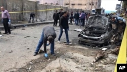 Para penyelidik menyusuri tempat ledakan bom di Alexandria, Mesir, 24 Maret 2018.