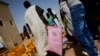 A man walks away with a bag of rice at a food distribution center in Tarenguel, in Mauritania's Gorgol region, May 30, 2012.