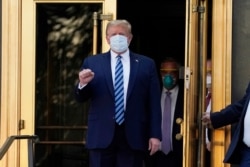 FILE - President Donald Trump walks out of Walter Reed National Military Medical Center to return to the White House after receiving treatments for COVID-19 in Bethesda, Maryland, Oct. 5, 2020.