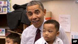 President Barack Obama sits with Marcus Wesby and other preschool student during his visit to Powell Elementary School in the Petworth neighborhood of Washington, March 4, 2014. 