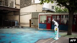 A worker sprays a gel on the ground to absorb lead during a decontamination operation at Saint Benoit school near Notre-Dame cathedral in Paris, Aug. 8, 2019. Tests continue to show worrying levels of the toxic metal at nearby schools.