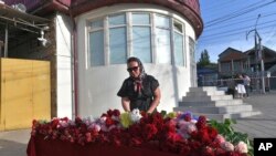 ស្ត្រី​ម្នាក់​ដាក់​ផ្កា​នៅ​កន្លែង​គោរព​វិញ្ញាណក្ខន្ធ​បណ្តោះអាសន្ន​នៅ​មុខ​វិហារ Holy Assumption បន្ទាប់​ពី​ការ​វាយ​ប្រហារ​ដោយ​ក្រុម​សកម្មប្រយុទ្ធ​អ៊ីស្លាម​នៅ​ក្នុង​ក្រុង Makhachkala នៃ​សាធារណរដ្ឋ Dagestan ប្រទេស​រុស្ស៊ី កាលពី​ថ្ងៃ​ចន្ទ ទី២៤ ខែ​មិថុនា ឆ្នាំ​២០២៤។