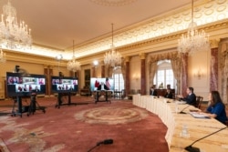 Secretary of State Antony Blinken, second from right, speaks during a virtual meeting at the State Department on Feb. 26, 2021, with Canadian Foreign Minister Marc Garneau who is in Ottawa, Canada.