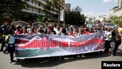 FILE - Members of Kenya's ruling Jubilee coalition carry a banner as they demonstrate in support of the Independent Electoral and Boundaries Commission (IEBC) the electoral body ahead of next year's election in Nairobi, Kenya, June 8, 2016. 