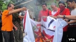 Kelompok Front Pancasila membakar lambang PKI di halaman Ismail Marzuki, sebagai bentuk penolakan simposium bertajuk "Membedah Tragedi 1965." (VOA/Fathiyah Wardah)