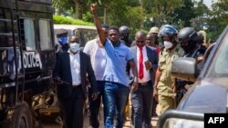 Ugandan musician turned politician Robert Kyagulanyi, also known as Bobi Wine, raises his arm as he walks to the court in Inganga, Nov. 19, 2020.