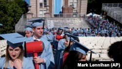 Students in the engineering department carry toy hammers as they arrive to receive their degrees at Columbia University's commencement, Wednesday, May 22, 2019 in New York.