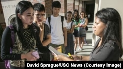Students submit documents to University of Southern California's International Academy during a 2014 orientation.