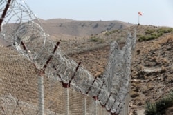FILE - A view of the border fence outside the Kitton outpost on the border with Afghanistan, in North Waziristan, Pakistan, Oct. 18, 2017.