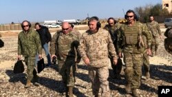 Gen. Frank McKenzie, center front, the top U.S. commander for the Middle East, walks as he visits a military outpost in Syria, Jan. 25, 2020. 