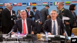 NATO Secretary General Jens Stoltenberg, right, and Montenegro's Prime Minister Milo Dukanovic, left, take their seats during a meeting of the North Atlantic Council and Montenegro at NATO headquarters in Brussels, May 19, 2016.