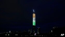 A high rise building is illuminated in the colors of the Indian tricolor flag on the eve of Independence Day in Kolkata, India, Aug. 14, 2018. 