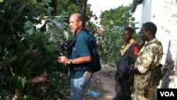 VOA's Peter Heinlein investigates wreckage from the "Black Hawk Down" incident near Mogadishu, Somalia, Aug. 13, 2011. (VOA Photo/G. Joselow)