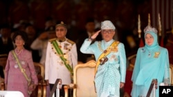 Raja Malaysia, Sultan Abdullah Sultan Ahmad Shah didampingi Ratu Tunku Azizah Aminah Maimunah (kanan), PM Mahathir Mohammad (dua dari kiri) dan istrinya Siti Hasmah dalam upacara penobatan Raja di gedung Parlemen, Kuala Lumpur, Malaysia, 31 Januari 2019.