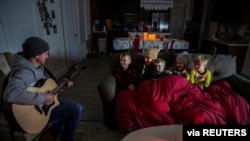 Brett Archibad, whose home was without electric power following winter weather, entertains his family as they try to stay warm in their home the BlackHawk neighborhood in Pflugerville, Texas, Feb. 16, 2021. (Ricardo B. Brazziell/via Reuters) 
