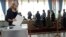 A woman casts her ballot as voters line up at a polling station during parliamentary elections in Minsk, Belarus, Sept. 11, 2016.