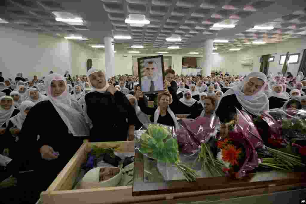 The wife of Israeli Chief Inspector Border Police officer Jedan Assad holds his photograph as she mourns during his funeral procession, in the Druse village of Beit Jann on Mt. Meron,&nbsp;Galilee, Israel, Nov. 6, 2014. 