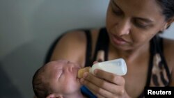 Daniele Ferreira dos Santos memberi susu kepada anaknya Juan Pedro, yang menderita microcephaly, sementara menunggu untuk diperiksa di Altino Ventura Foundation, pusat pengobatan di Recife, negara bagian Pernambuco, Brazil, 4 Februari 2016. 