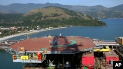 FILE - Petrobras workers walk on platform 51 "Majuro" in Angra dos Reis, Brazil, Aug. 21, 2008. (AP Photo/Ricardo Moraes, File)