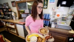 Waitress Laura Haege delivers breakfast at the Waveland Cafe in Des Moines, Iowa, 2015. (AP Photo/Charlie Neibergall)