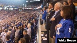 Wakil Presiden Amerika Serikat, Mike Pence dan Istri, Karen Pence, dan Mayor Jenderal Courtney P. Carr berdiri pada saat menyanyikan lagu kebangsaan di Lucas Oil Stadium, sebelum pertandingan antara Indiana Colts melawan Francisco 49ers dimulai. Gambar diambil sebelum Pence meninggalkan pertandingan, 8 Oktober 2017.