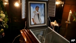 FILE - A picture of slain journalist Gumaro Perez stands on his open casket during a wake inside his mother's home in Acayucan, Veracruz state, Mexico, Dec. 20, 2017.