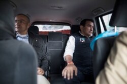 Wilson Florez, right, candidate for the government of Cundinamarca of the Democratic Center political party, sits in an armored vehicle next to his bodyguard, in Bogota, Colombia, Oct. 23, 2019.