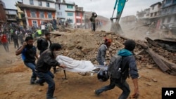 Beberapa sukarelawan membawa tandu berisi mayat korban gempa yang ditemukan diantara reruntuhan bangunan yang ambruk setelah gempa di Kathmandu, Nepal, 25 April 2015. (AP Photo/ Niranjan Shrestha)