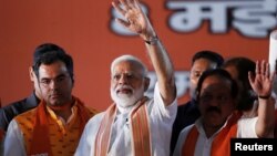 PM India Narendra Modi (tengah) melambai kepada para pendukungnya di New Delhi. 