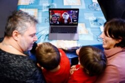 Gabriele Vinzi, 3, and his brother Samuele Vinzi, 4, react along with their parents as they receive a call via Zoom by a man dressed as Santa Claus, amid theCOVID-19 pandemic, in Rome, Italy, Dec. 8, 2020.