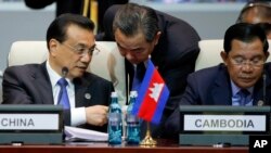 Chinese Premier Li Keqiang, left, talks with Foreign Minister Wang Yi, center, as he and Cambodia's Prime Minister Hun Sen, right, attend the opening session of the Asia-Europe Meeting (ASEM) summit in Ulaanbaatar, Mongolia July 15, 2016. 