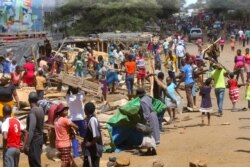 People clear destroyed stalls in the area of a popular market in a campaign to clean up the city, in Harare, Zimbabwe, April 18, 2020.