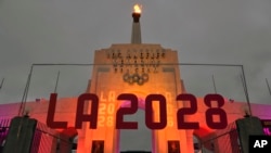 Tulisan LA 2028 terpasang di depan kaldron Olimpiade di Los Angeles Memorial Coliseum, pada 13 September 2017. (Foto: AP/Richard Vogel)