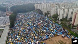 In this Tuesday, Dec. 12, 2017 photo, improvised homes create the squatter community coined "Povo Sem Medo," or Fearless People, in Sao Bernardo do Campo, a suburb pf Sao Paulo, Brazil. (AP Photo/Andre Penner)