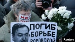 ស្រ្តី​ម្នាក់​កាន់​រូប​លោក​មេធាវី Sergei Magnitsky ក្នុង​ពេល​ប្រមូល​ផ្តុំ​មួយ​នៅ​ក្នុង​ក្រុង​មូស្គូ កាលពី​ថ្ងៃទី១៥ ខែធ្នូ ឆ្នាំ២០១២។