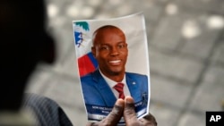Seseorang memegang foto mendiang Presiden Haiti Jovenel Moise saat upacara peringatannya di Museum Pantheon Nasional di Port-au-Prince, Haiti, 20 Juli 2021. (Foto: AP)