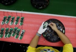 An employee works on the production line of a robot vacuum cleaner factory of Matsutek in Shenzhen, China, Aug. 9, 2019.