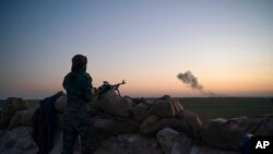 FILE - Smoke rises after an airstrike hit territory held by Islamic State militants in a desert in Syria, Feb. 19, 2019. U.S. strikes in late October 2024 have hit Islamic State group camps in Syria, killing up to 35 militants, the U.S. reports.